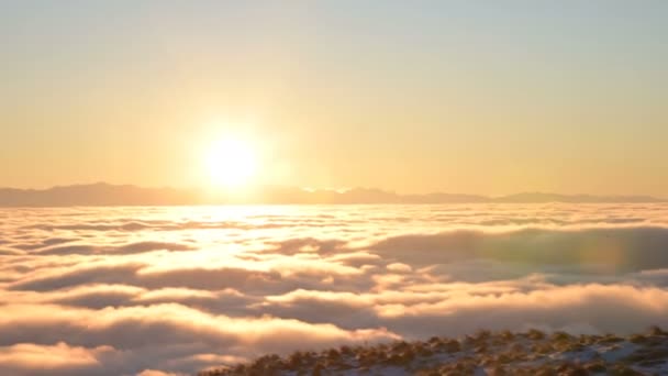 Coucher de soleil sur des nuages blancs, vue depuis des montagnes couvertes d'herbe et de neige .