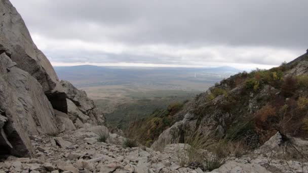 Vista desde las montañas rocosas hasta el valle en un día nublado y ventoso. Cáucaso Norte — Vídeos de Stock