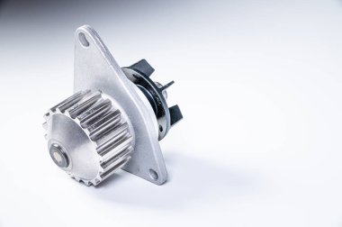 Gri arka planda bir su pompasının motorunu soğutmak için yeni metal otomobil pompası. Araba motoru için yeni yedek parça kavramı