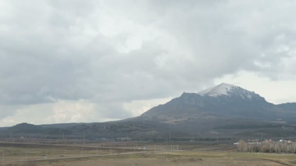 Άποψη της κοιλάδας, δρόμος με αυτοκίνητα, βουνό σε συννεφιασμένη μέρα. Ψηλά πόδια. Βόρειος Καύκασος — Αρχείο Βίντεο