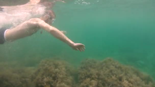 Cienki człowiek z brodą w masce pływa pod wodą, machając rękami. Zbliżenie. — Wideo stockowe