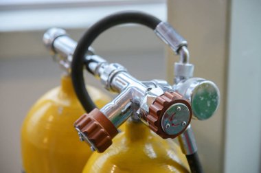 Eski sarı, tüplü dalış ve tüplü dalış için iki hava tankı. Su altı dünyasını keşfetmek için klasik ekipmanlar. Hava ayarlama düğmesine yakın çekim