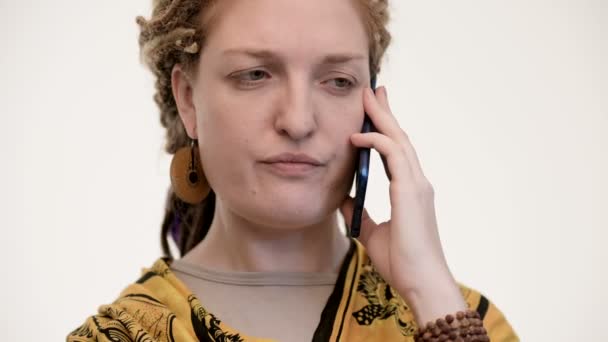 Etnische vrouw aan de telefoon, argumenteert. Witte achtergrond. Sluitingsdatum — Stockvideo