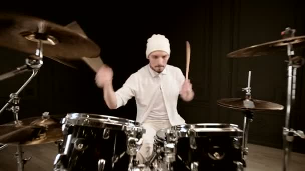 穿着白色衣服的帅哥在黑色背景的鼓包上积极地演奏. 包扎 — 图库视频影像