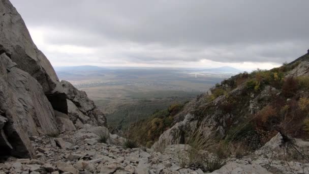 Pohled z skalnatých hor do údolí za oblačného větrného dne. Severní Kavkaz — Stock video