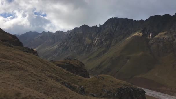 Панорама альпійської місцевості на Північному Кавказі, де гори є скелями і низькою хмарністю. — стокове відео