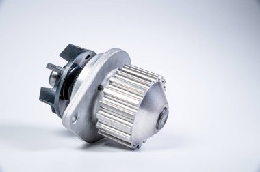 Gri arka planda bir su pompasının motorunu soğutmak için yeni metal otomobil pompası. Araba motoru için yeni yedek parça kavramı