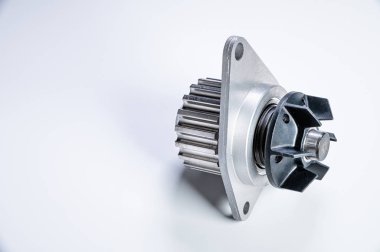 Gri arka planda bir su pompasının motorunu soğutmak için yeni metal otomobil pompası. Araba motoru için yeni yedek parça kavramı