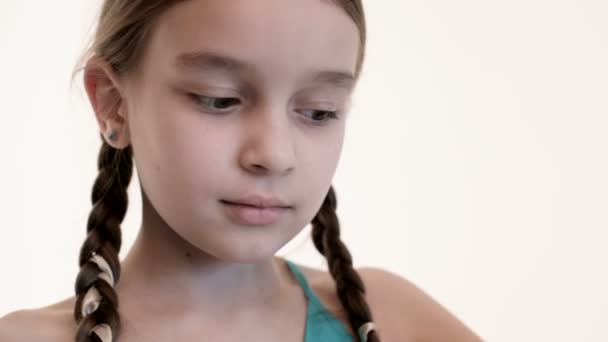 새끼가 달린 소녀는 흰 배경에 찢어진 장난감 곰의 머리를 들고 있다. 클로즈업 — 비디오