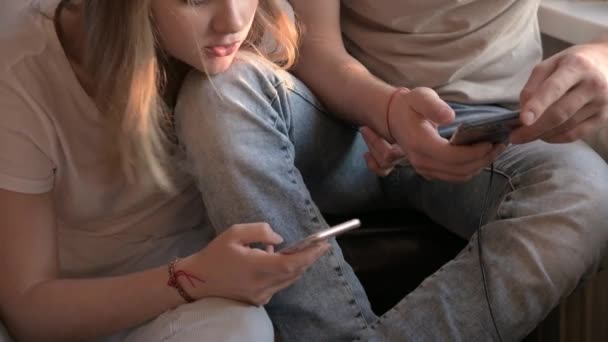 Casal jovem conversando telefones celulares no quarto. Homem e mulher focados. Close-up — Vídeo de Stock