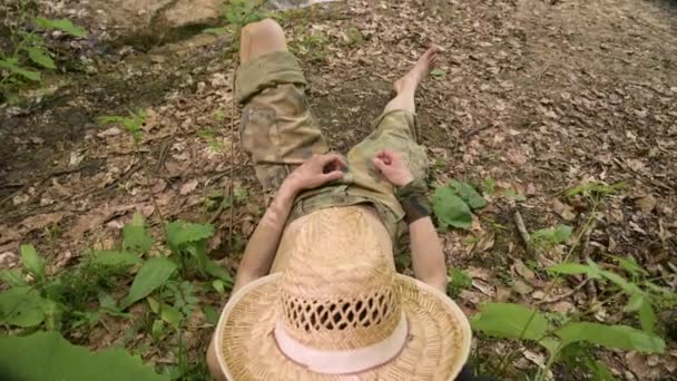 Viajero en pantalones militares se pasea en el suelo en el bosque, durmiendo. Primer plano, sartén — Vídeos de Stock