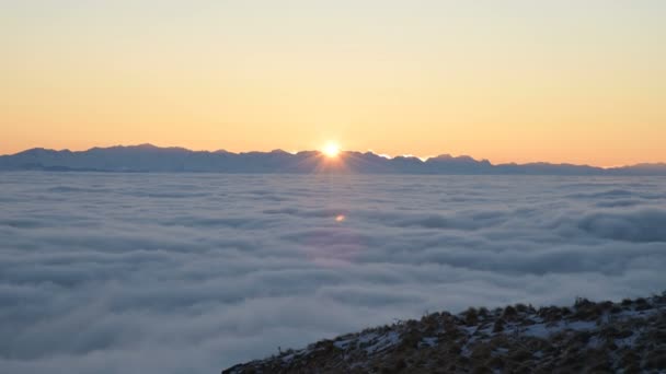 白い雲の上に夕日、山からの眺め。太陽が尾根を越えて行った. — ストック動画