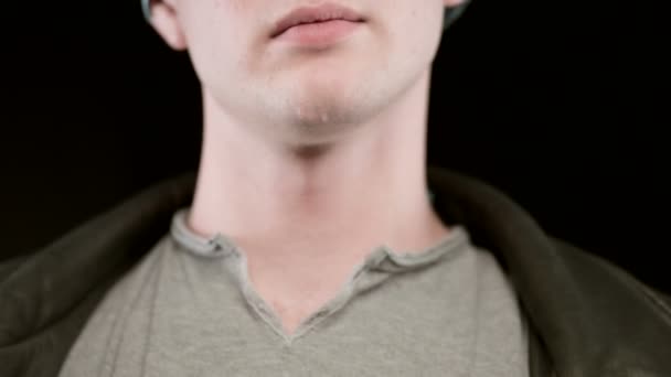 Young man puts medical gown. Doctor, uniform. Black background, studio, close-up — Stock Video