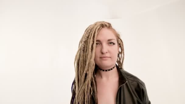 Kvinna i svart skinnjacka, med dreadlocks sittande stol. Närbild. — Stockvideo