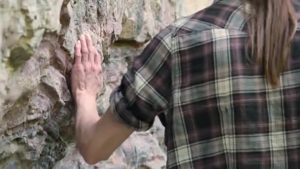 Ung man i hatt går barfota längs bergsvägen, ser fram emot. — Stockvideo