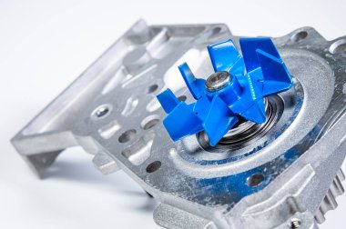Gri arka planda bir su pompasının motorunu soğutmak için yeni metal otomobil pompası. Araba motoru için yeni yedek parça kavramı