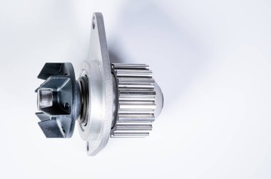 Gri arka planda bir su pompasının motorunu soğutmak için yeni metal otomobil pompası. Araba motoru için yeni yedek parça kavramı