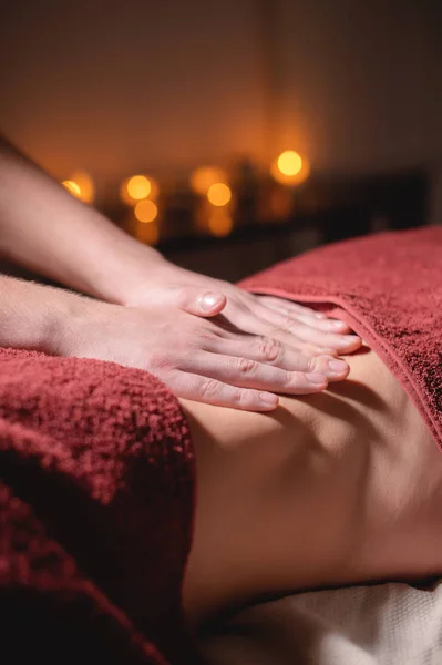 Middelhoog schot ondiepe scherptediepte. Professionele elite massage van de buik anti-cellulitis en nuttig voor inwendige organen in een donkere massageruimte — Stockfoto