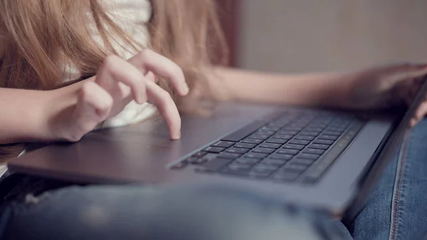 Laptop klavyesinde küçük bir kızın elinin sığ derinliği. Genç nesil aletleri kullanma fikri. — Stok fotoğraf