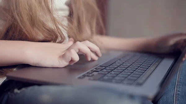Laptop klavyesinde küçük bir kızın elinin sığ derinliği. Genç nesil aletleri kullanma fikri. — Stok fotoğraf