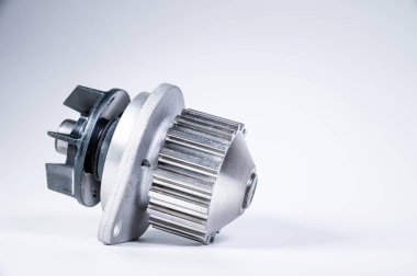 Gri arka planda bir su pompasının motorunu soğutmak için yeni metal otomobil pompası. Araba motoru için yeni yedek parça kavramı
