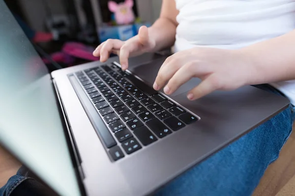 Крупним планом неглибока глибина поля маленьких дівчат рука на клавіатурі ноутбука. Концепція використання молодого покоління гаджетів — стокове фото