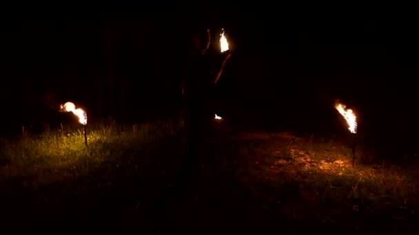 Slow-mo of man in dark rotates burning ball poi. Low key. Fire show. Close-up. — 비디오