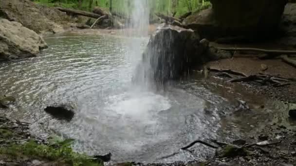 Cascada. Una poderosa corriente de agua fluye por piedras y troncos. Primer plano, sartén — Vídeos de Stock