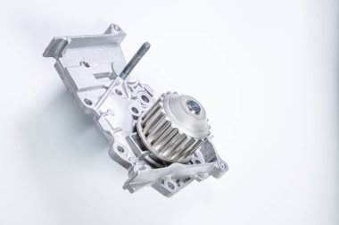 Gri arka planda bir su pompasının motorunu soğutmak için yeni metal otomobil pompası. Araba motoru için yeni yedek parça kavramı