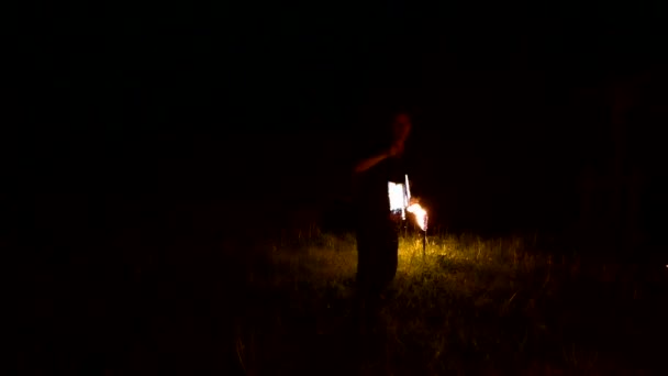 Slow-mo of man in dark rotates burning ball poi. Low key. Fire show. Close-up. — 비디오