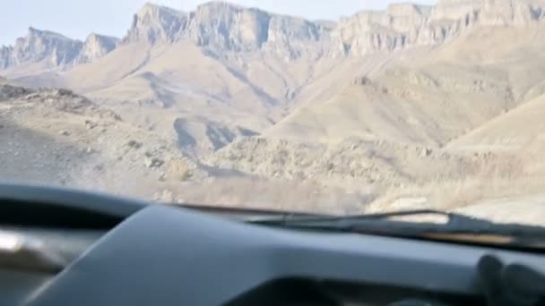 Вид с машины на проселочную дорогу среди гор, шипы. Северный Кавказ — стоковое видео