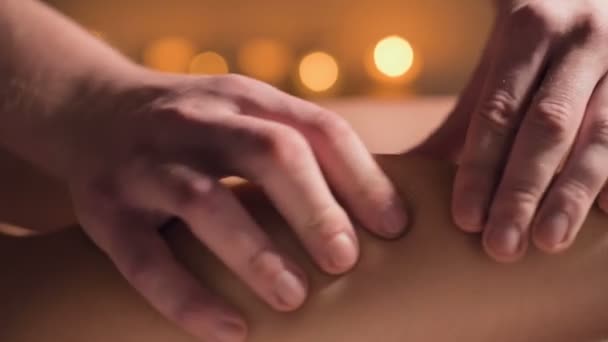 Detailní záběr prémiové masáže stehen proti celulitidě. Mužské ruce masírují pacientce stehno v útulné pracovně se slabým světlem. Luxusní masážní služby — Stock video