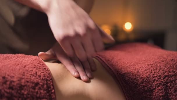Невелика глибина різкості. Професійний елітний масаж живота антицелюлітний і корисний для внутрішніх органів в темній кімнаті масажу — стокове відео