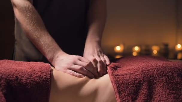 Middelhoog schot ondiepe scherptediepte. Professionele elite massage van de buik anti-cellulitis en nuttig voor inwendige organen in een donkere massageruimte — Stockvideo