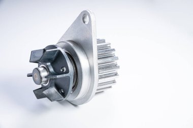 Gri arka planda bir su pompasının motorunu soğutmak için yeni metal otomobil pompası. Araba motoru için yeni yedek parça kavramı