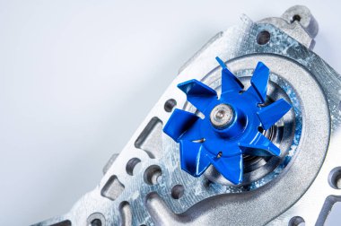 Gri arka planda bir su pompasının motorunu soğutmak için yeni metal otomobil pompası. Araba motoru için yeni yedek parça kavramı