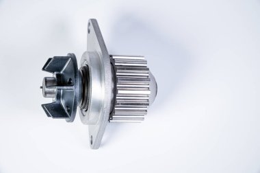 Gri arka planda bir su pompasının motorunu soğutmak için yeni metal otomobil pompası. Araba motoru için yeni yedek parça kavramı