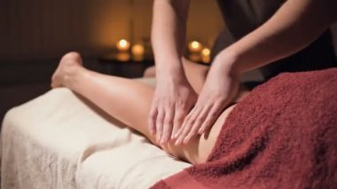 Premium anti-selülit kalça masajı. Erkek eller, loş ışıkla rahat bir çalışma odasında hasta kıza sağlıklı bir masaj yapar. Lüks masaj hizmetleri