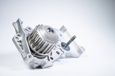Gri arka planda bir su pompasının motorunu soğutmak için yeni metal otomobil pompası. Araba motoru için yeni yedek parça kavramı