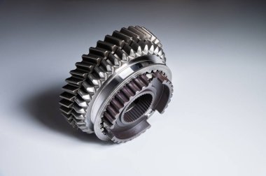 Gri arka planda yeni parçalar. Vites değiştiren tork şanzımanı. Kavramsal olarak mekanik arka plan. Parlak vites kutusu dişleri