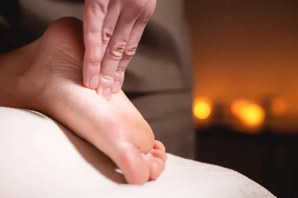 Close-up reflexology foot massage. Male masseur makes foot massage to a female client. Foot Care Concept
