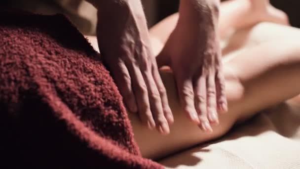 Nahaufnahme einer erstklassigen Anti-Cellulite-Schenkelmassage. Männliche Hände massieren in einer gemütlichen Studie mit schummrigem Licht den Oberschenkel der Patientin. Luxusmassagen — Stockvideo