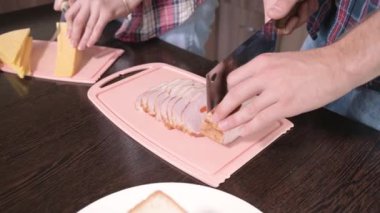 Adam et dilimlerini karatahtanın üzerinde büyük bir bıçakla kesiyor. Yakın plan.