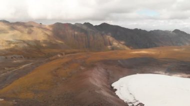 Dağlardaki volkanik kayaların üzerinden Elbrus Dağı 'nın arka planına ve büyük bir buzulun üzerine alçak uçuşlar. Dağ Seyahati ve Tırmanma Kavramı Uhd 4k