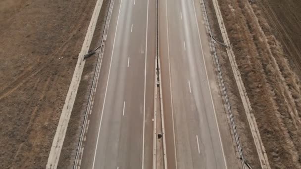Aerial top view of a suburban transport road in autumn or winter without snow. Cars drive on the motorway. — Stock Video