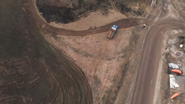 Vue aérienne d'un camion à benne vide roulant le long d'un chemin de terre. Le concept de travaux de construction et l'élimination des déchets de construction