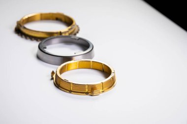 Vites kutusundaki şanzımanların bireysel elemanları. Gri arkaplandaki pirinçten yapılmış yeni bir senkronizatör takımı.