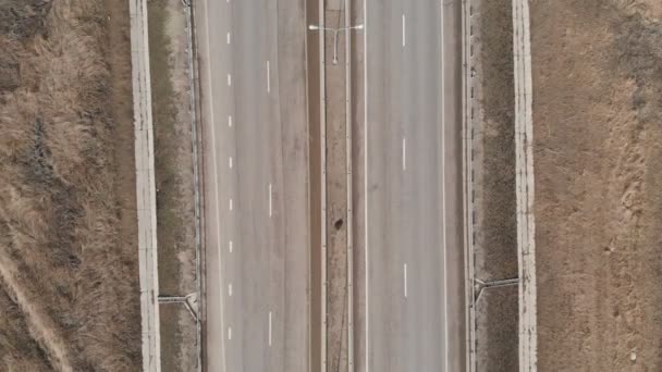 Vista aérea de una carretera de transporte suburbano en otoño o invierno sin nieve. Los coches conducen por la autopista. — Vídeos de Stock