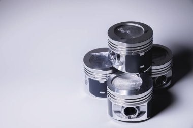 İçten yanmalı motor için yeni parçalar. Gri eğimli arkaplanda tabancalar