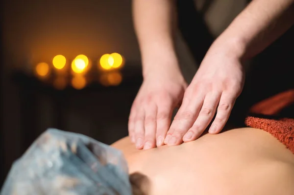 Profesionální masáž detailní záběr tmavé místnosti na pozadí svíček. Luxusní masážní služby pro ženu. Malá klávesa — Stock fotografie